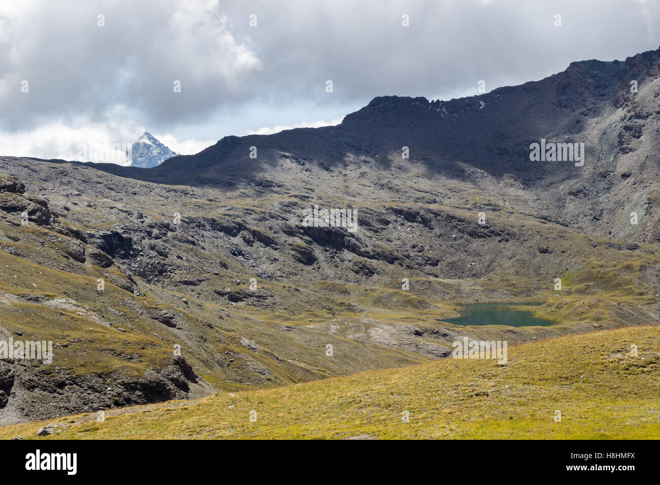 Hiking trail in Aosta Valley, Italy. Alpine lake of Doreire. Stock Photo