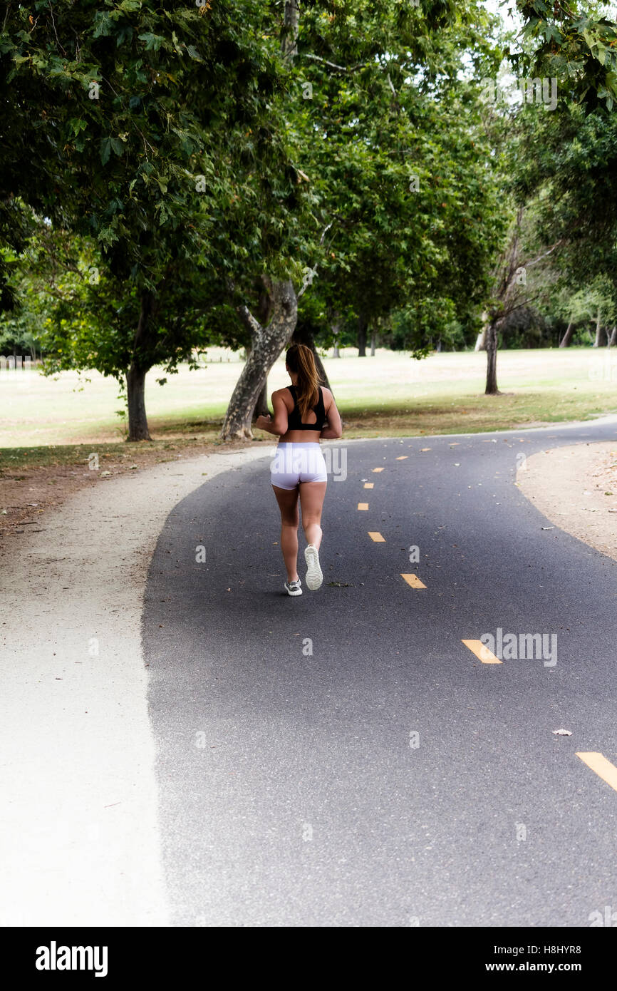 Attractive Caucasian Teen Girl Running On Bike Trail Back To Camera Stock Photo