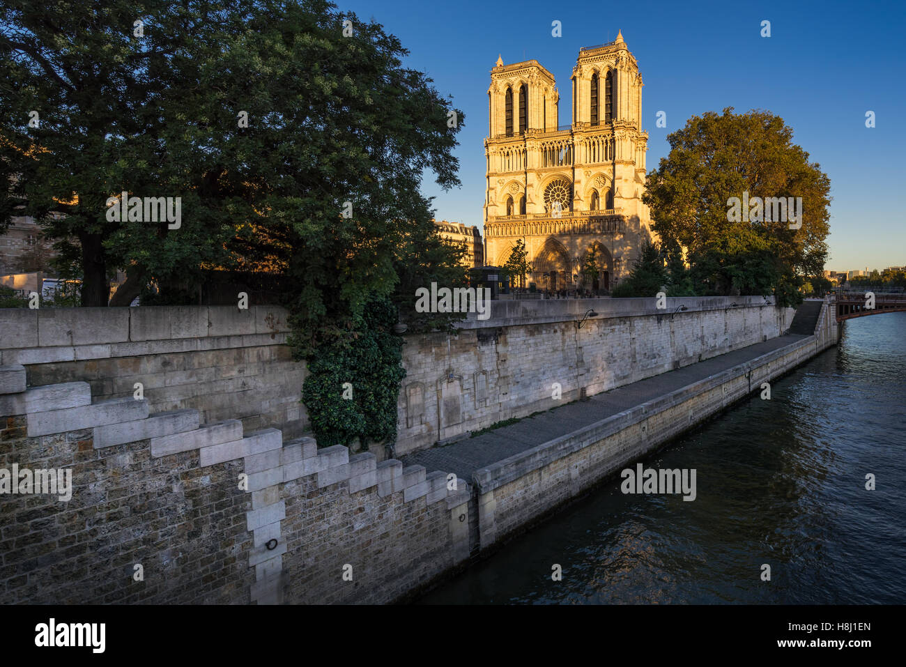 Notre Dame de Paris cathedral at sunset with the Seine River on Ile de La Cite. 4th Arrondissement, Paris, France Stock Photo