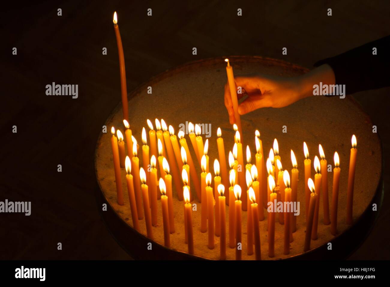 Woman hand lighting candles in a church Stock Photo Alamy