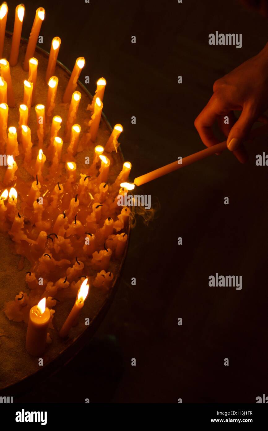 Woman hand lighting candles in a church Stock Photo Alamy