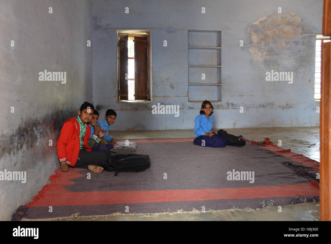 Indian kids sitting on the floor in their classroom in a poor village school in Rajasthan, India Stock Photo