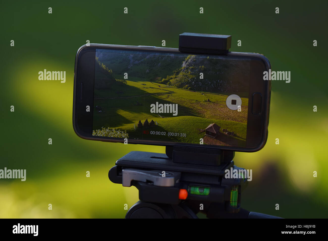 Smartphone on tripod recording timelapse in the sunset with rural mountain landscape background Stock Photo