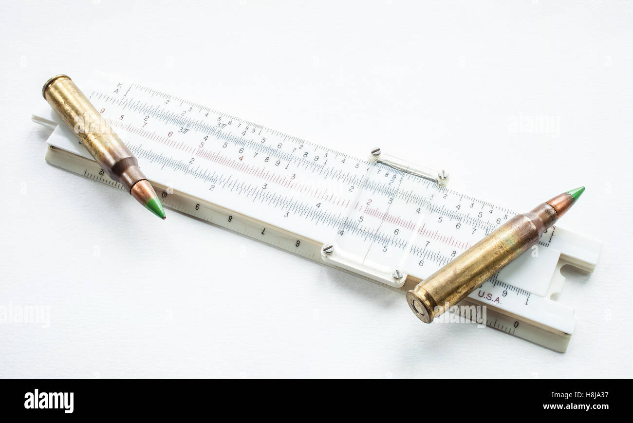 Polymer sliderule and green tipped 5.56 cartridges on white Stock Photo