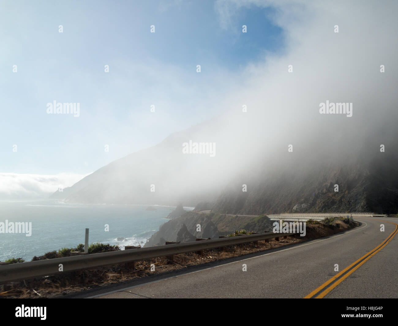 Clouds over the mountains by Cabrillo Highway crossing Big Sur aside the Pacific Ocean Stock Photo