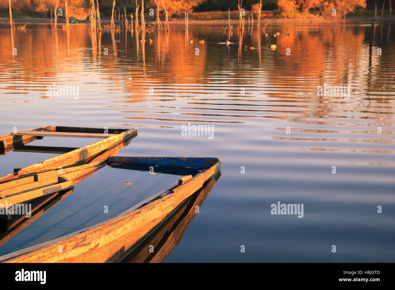 Wooden fishing boats at sunset on river or lake Stock Photo