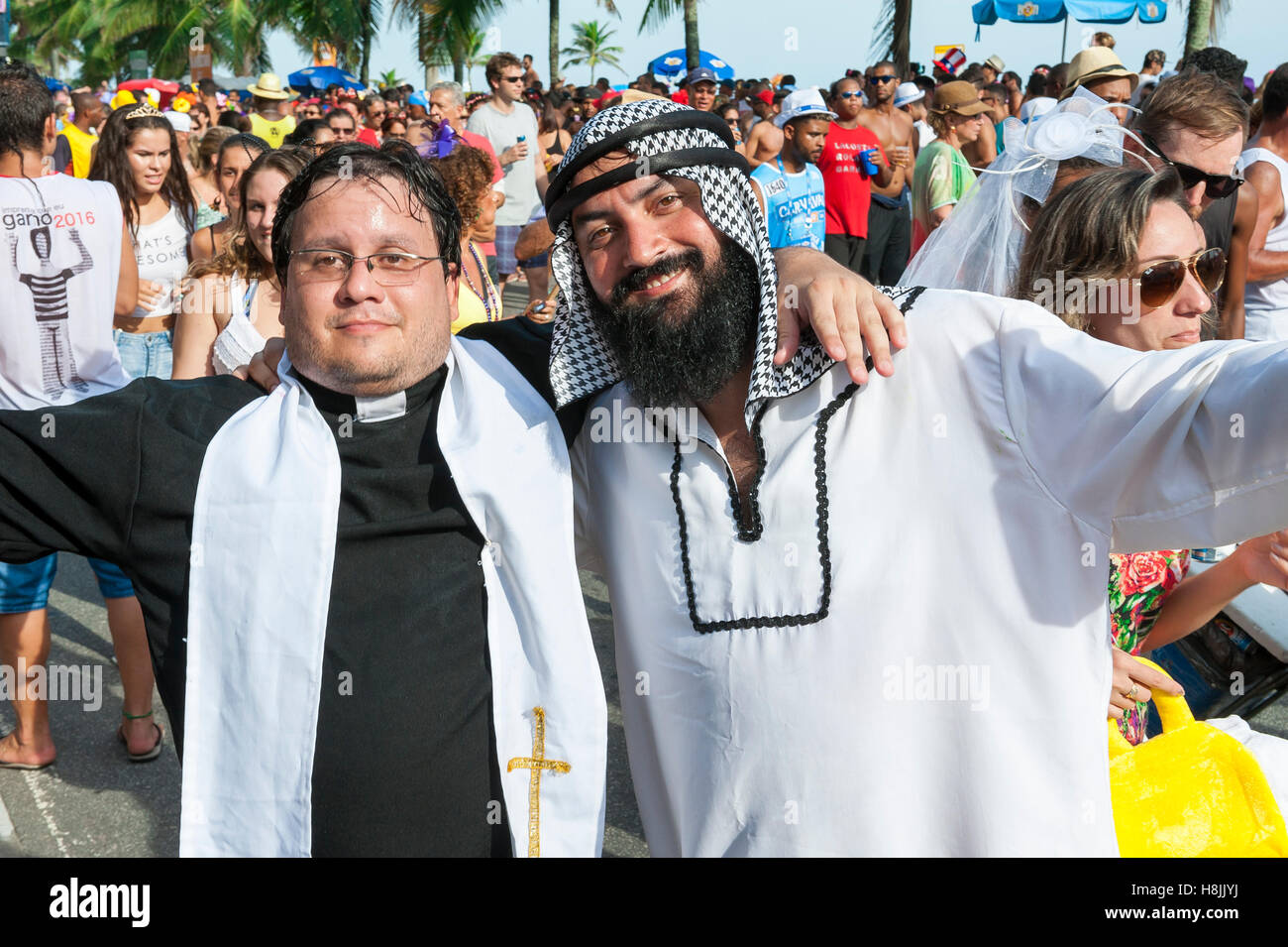 RIO DE JANEIRO - FEBRUARY 07, 2015: Brazilians celebrate carnival in religious costumes, one Christian, one Muslim, at carnival. Stock Photo