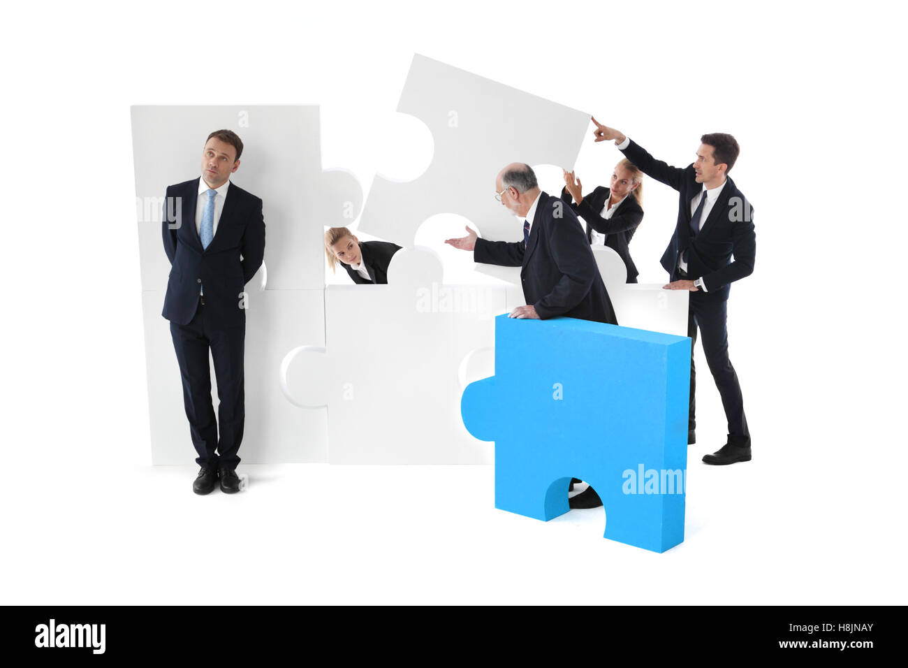 Lazy businessman and business team working concept, people assembling puzzle isolated on white Stock Photo