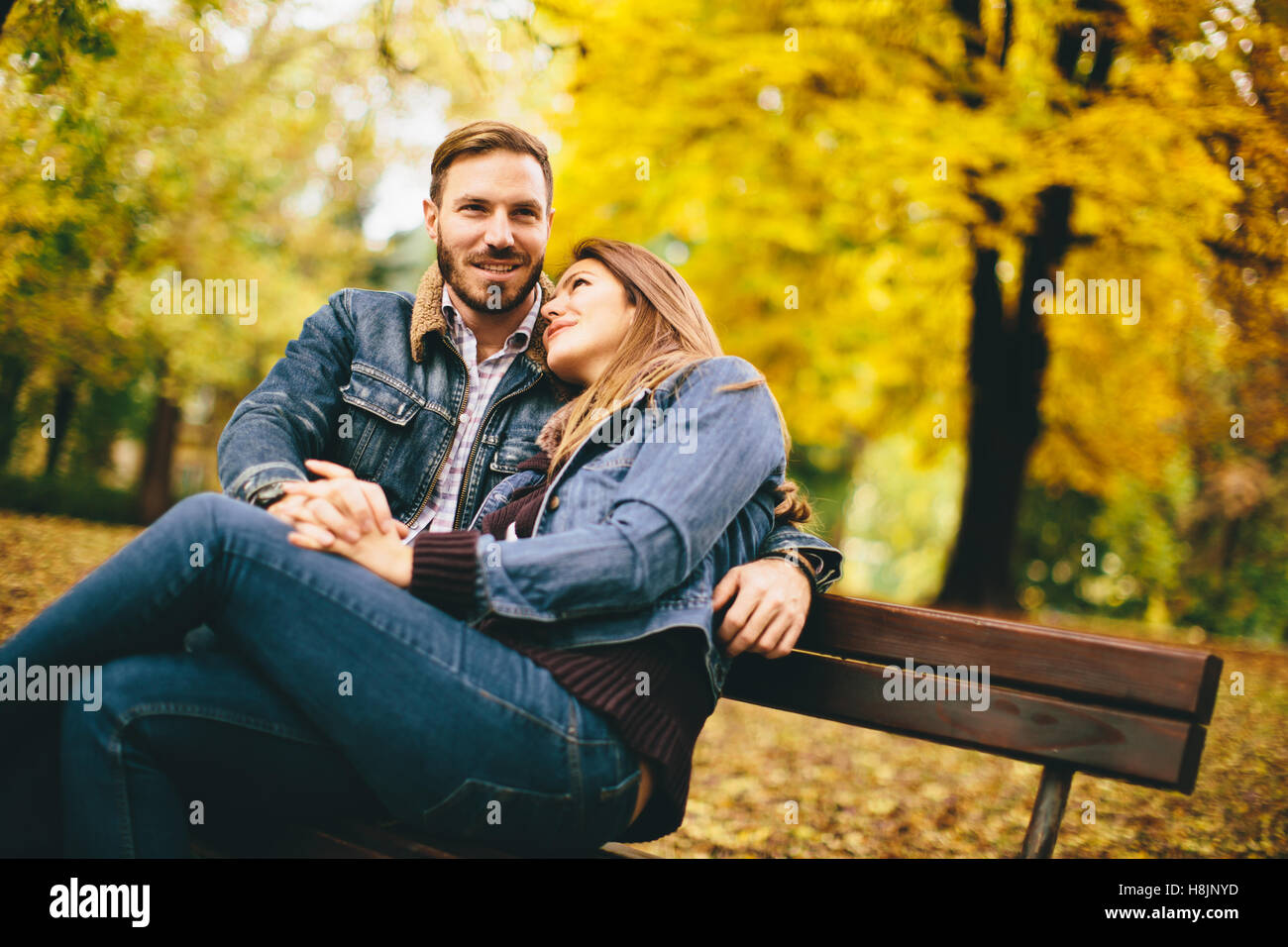 Loving and romantic couple on a bench in the autumn park Stock Photo ...