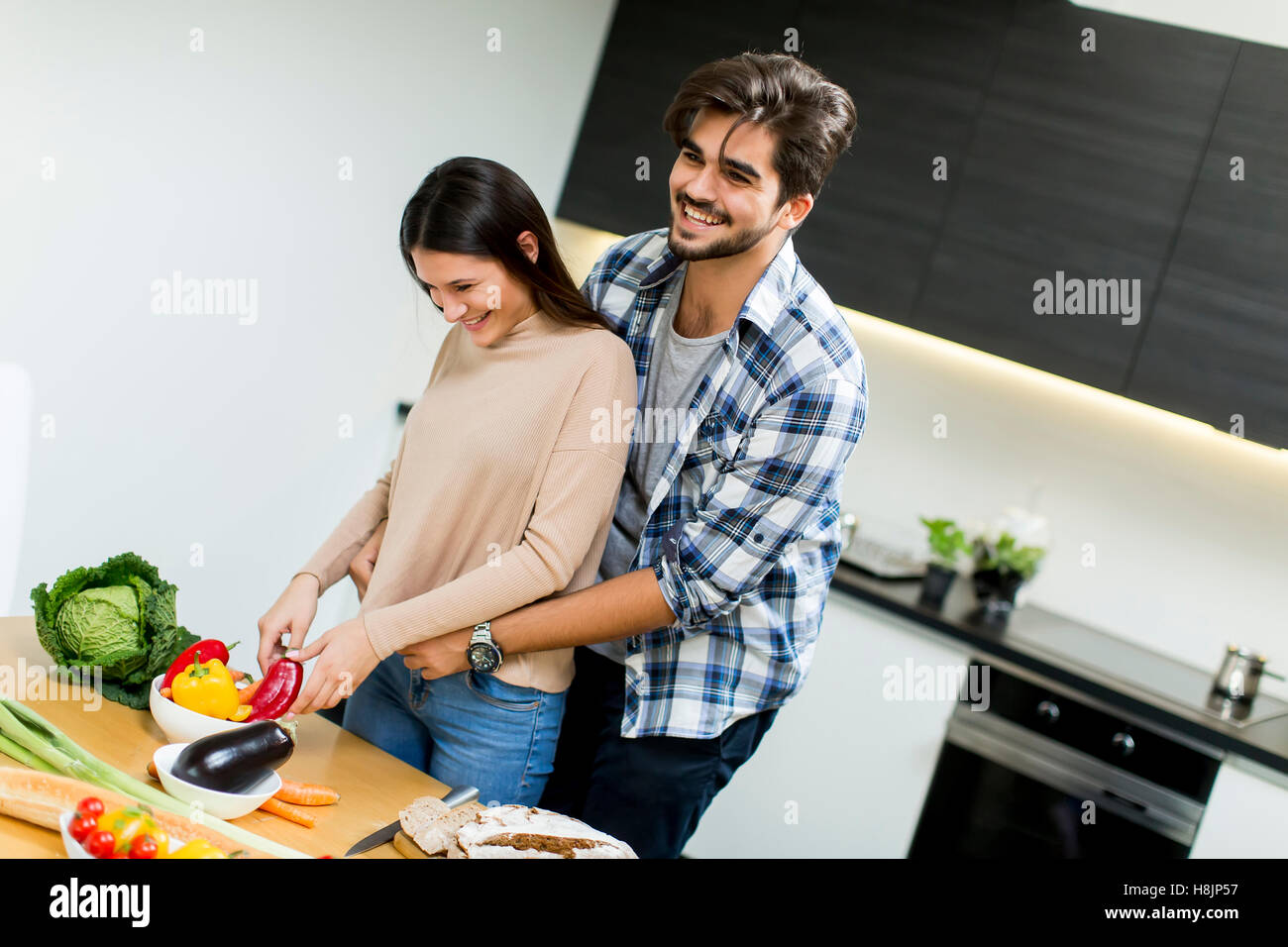 Lovely young couple preparing fresh food in the modern kitchen Stock Photo