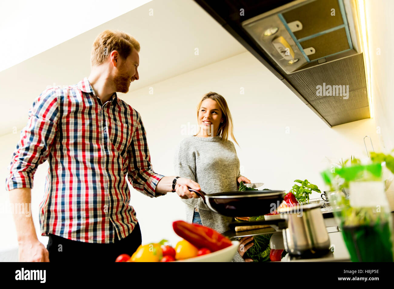 Happy young couple preparing food in the kitchen Stock Photo