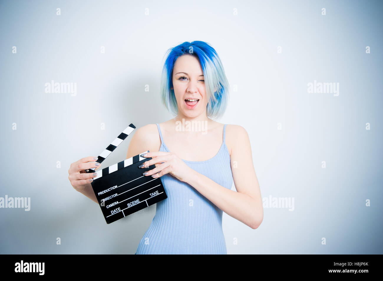 Teen alternative hipster girl smiling and wink with movie clapper board for actress audition Stock Photo