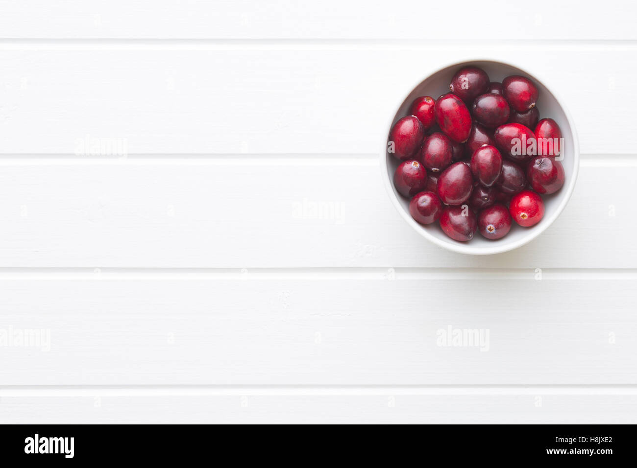 The tasty american cranberry in bowl on white table. Stock Photo