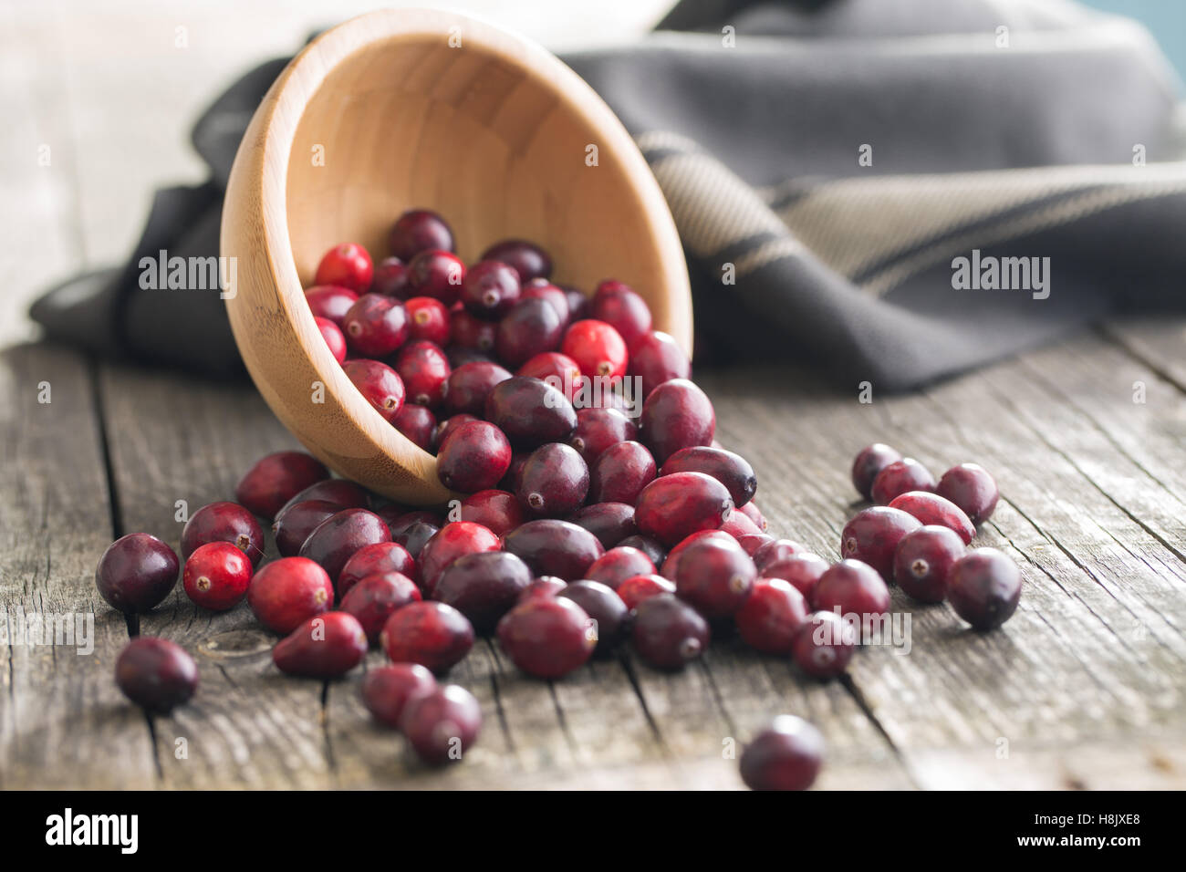 The tasty american cranberries in bowl on old wooden table. Stock Photo