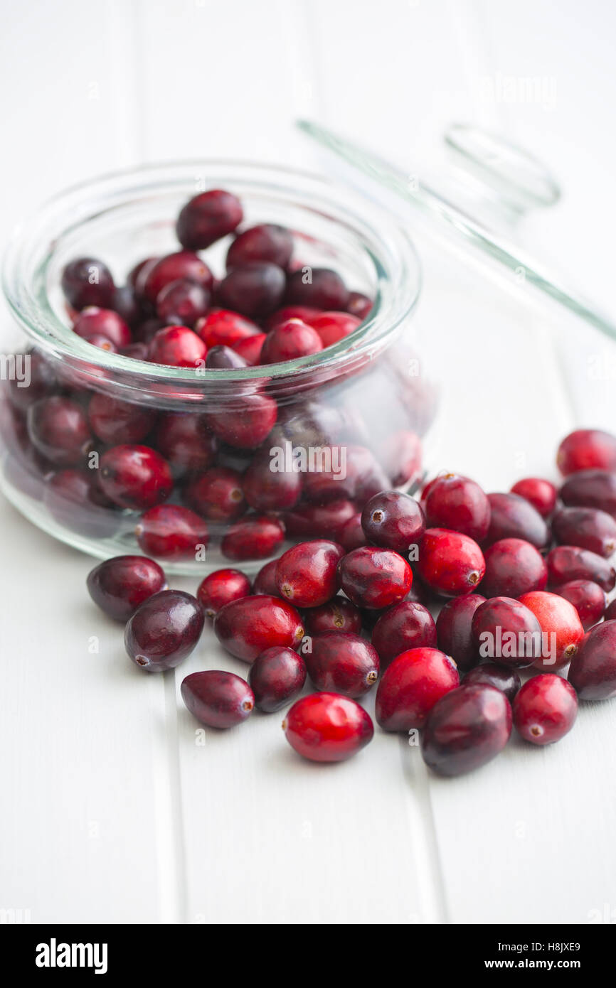 The tasty american cranberries in jar on white table. Stock Photo