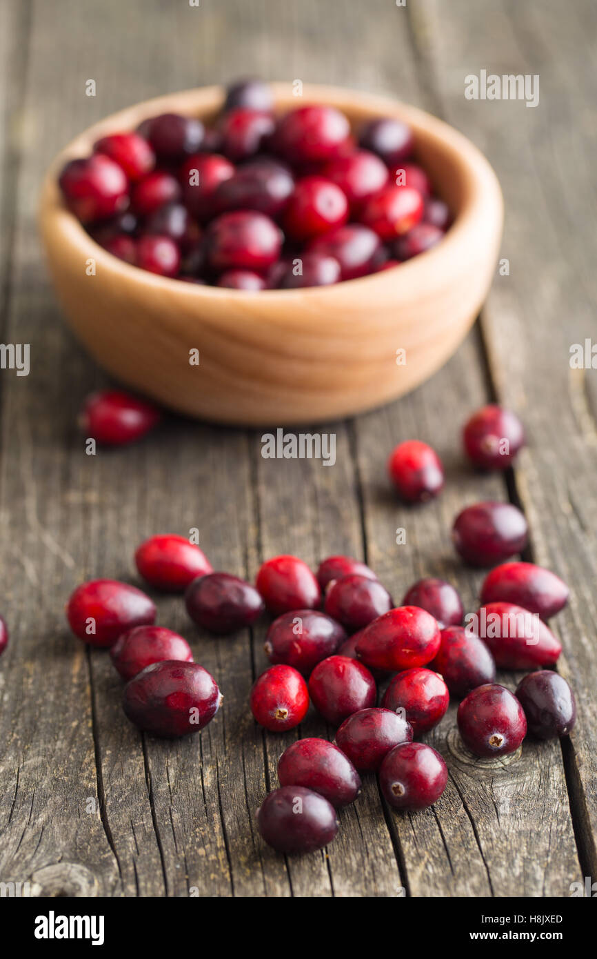 The tasty american cranberries in bowl on old wooden table. Stock Photo