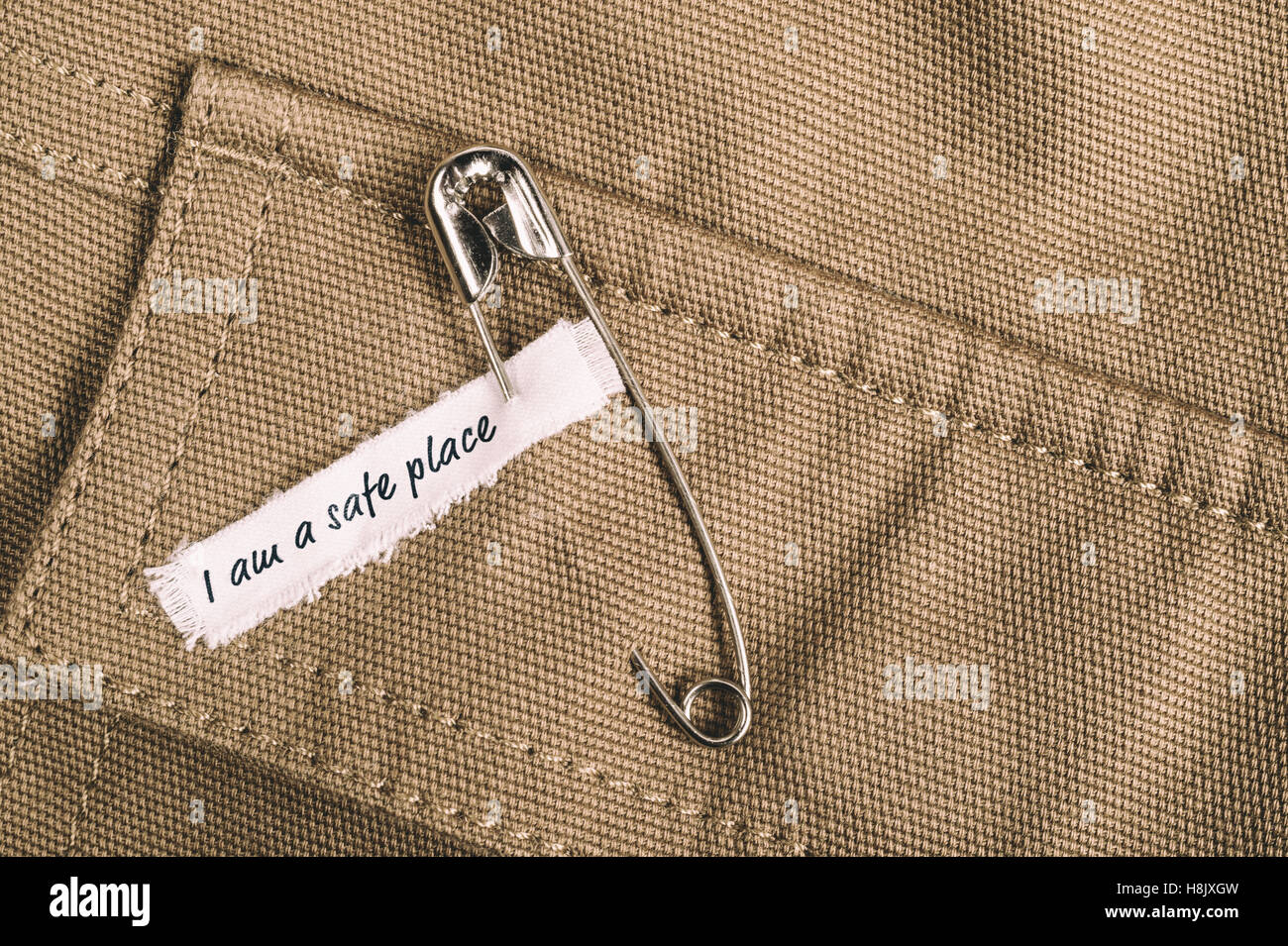 Safety pin on clothes with label I am a safe place as a symbol of  solidarity Stock Photo - Alamy