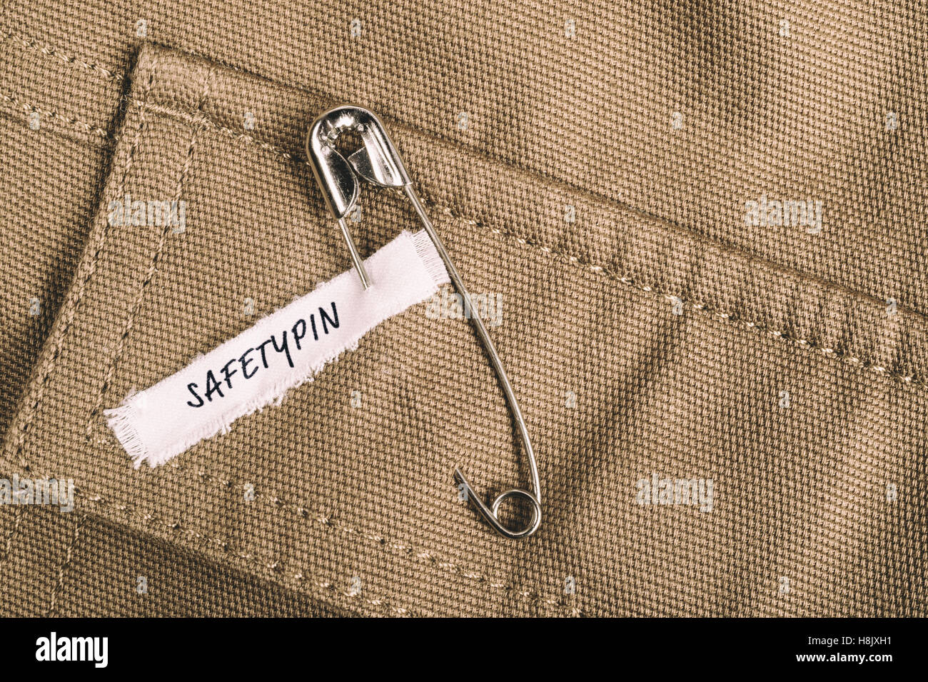 Safety pin on clothes with label "Safetypin" as a symbol of solidarity
