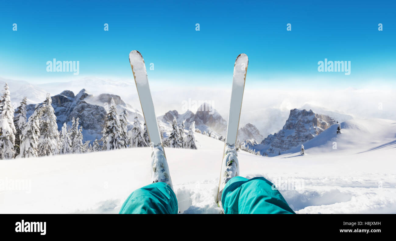 Detail of alpine skier legs, watching the valley panorama. Winter equipment, vacation concept, copyspace for text Stock Photo