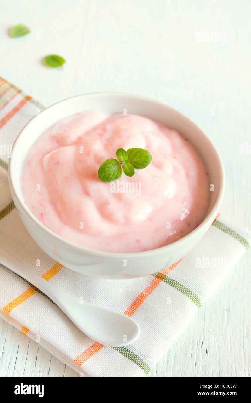 Strawberry yogurt with mint on wooden white background. strawberry yoghurt. pink yogurt. Stock Photo