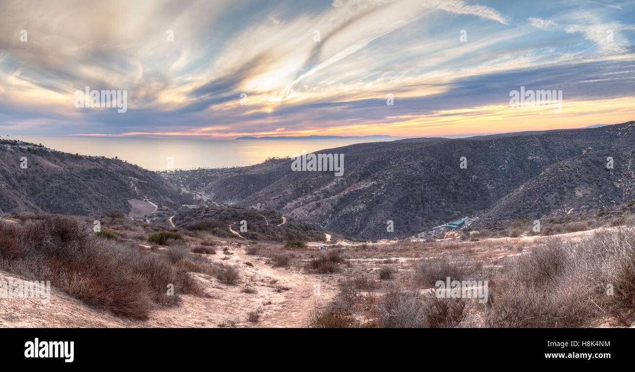 Laguna Canyon Road leading to the ocean from Top of the World hiking trail in Laguna Beach at sunset Stock Photo