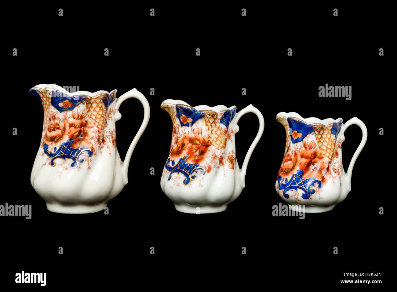 Antique trio of British hand painted porcelain milk jugs Stock Photo