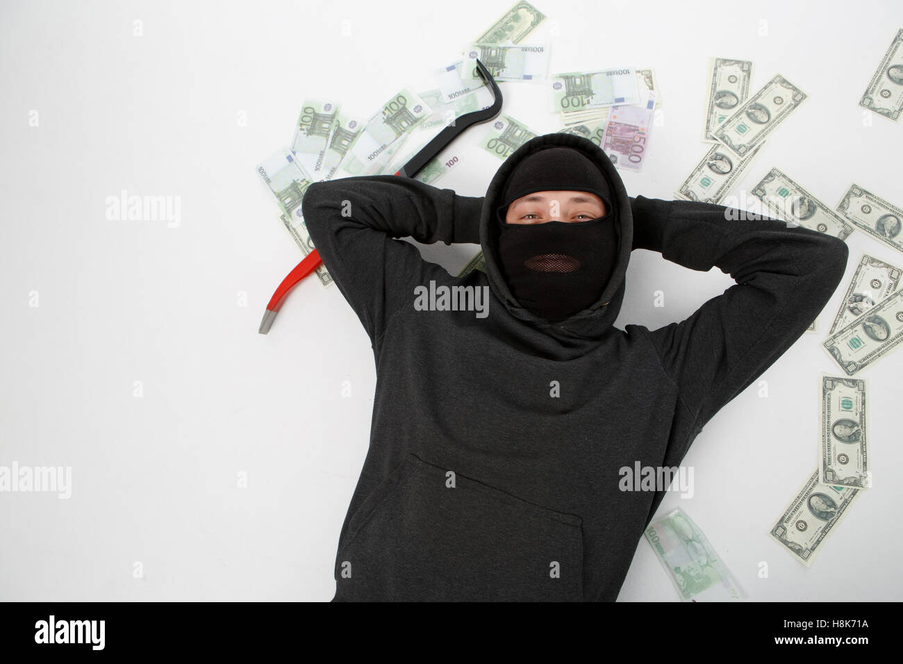 Satisfied burglar lies on floor Stock Photo