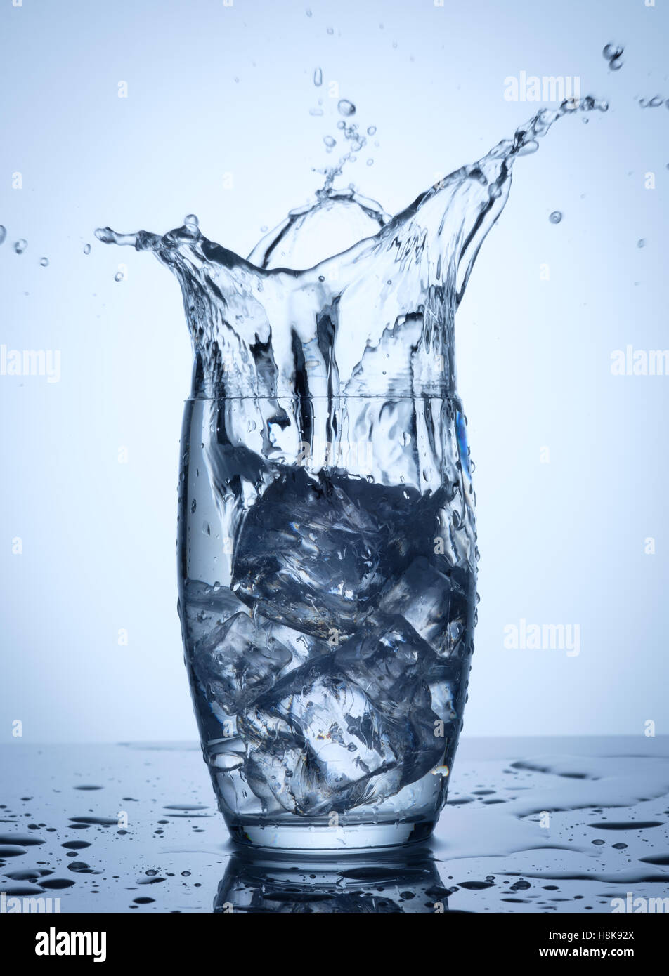 Water splash in glass with ice cubes Stock Photo - Alamy