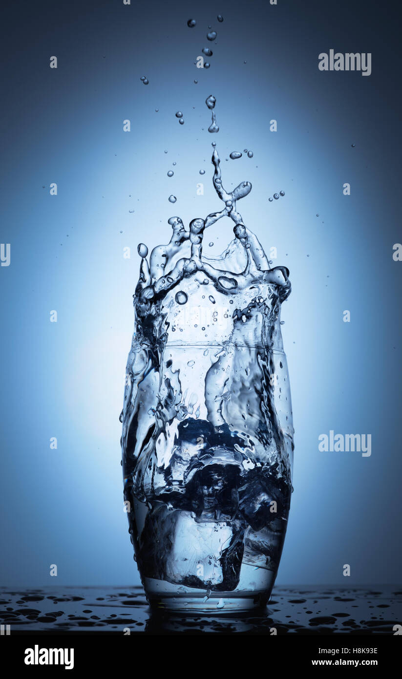 Water splash in glass with ice cubes Stock Photo - Alamy