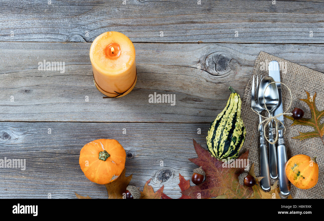 Dinner place setting for Thanksgiving Autumn holiday in horizontal layout on rustic wooden boards. Stock Photo