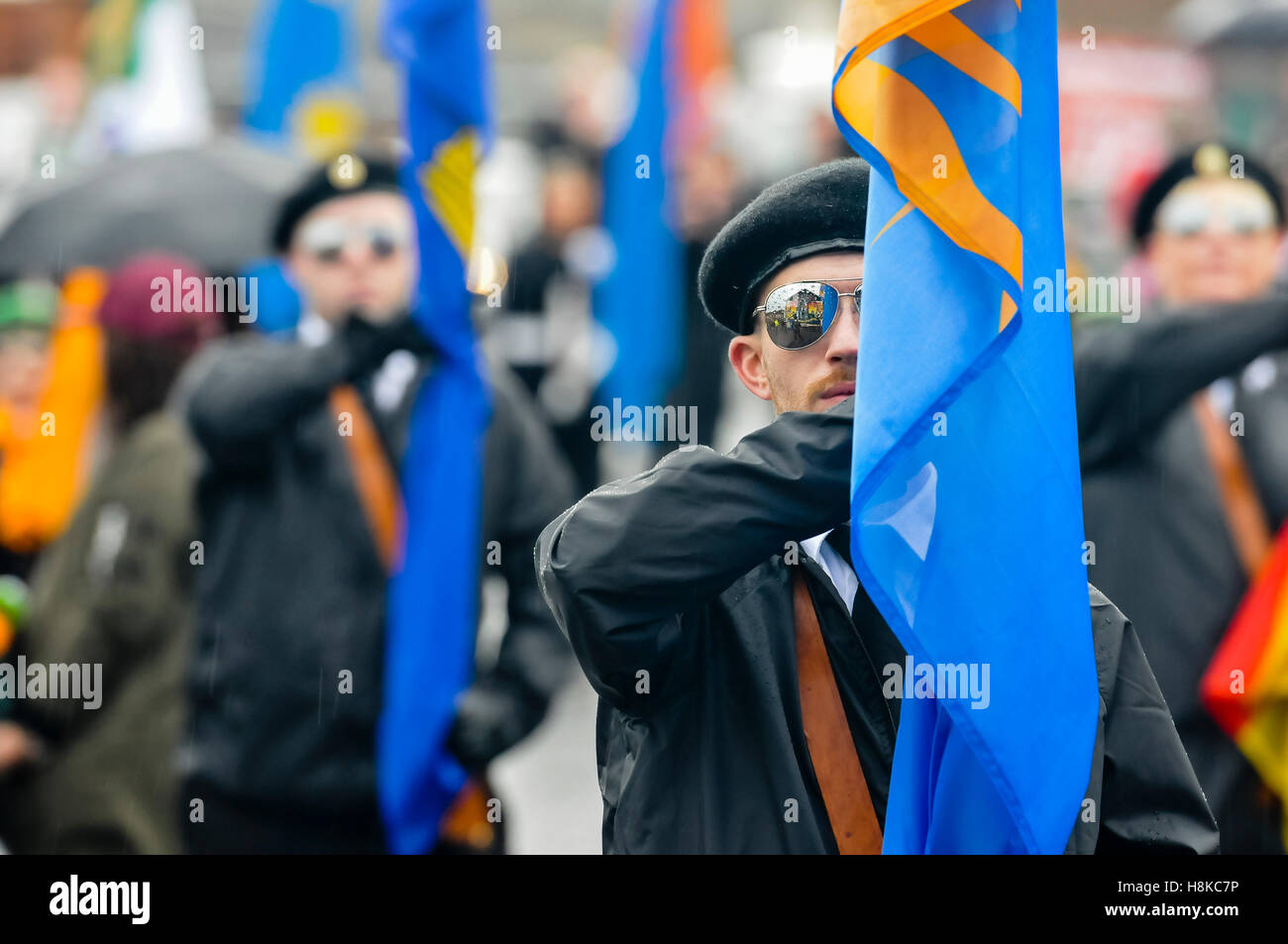 Belfast, Northern, Ireland. 13th Nov, 2016. A republican mural is reflected in the mirrored sunglasses of the main flagbearer at a Republican parade in remembrance of Vol. Patricia Black, who died 15 Nov 1991. Credit:  Stephen Barnes/Alamy Live News Stock Photo