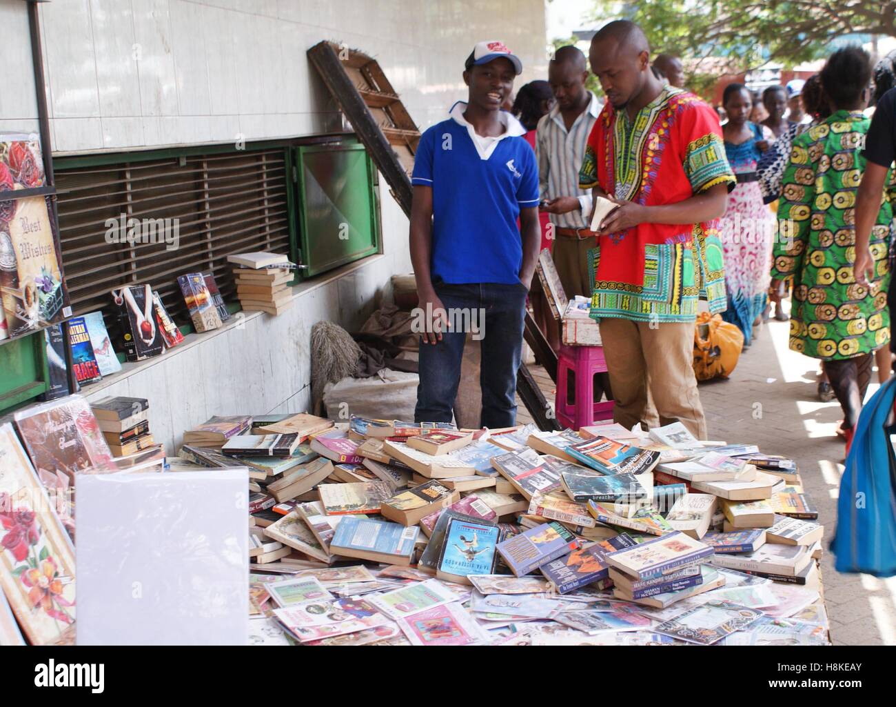 Francis Mbinda (L), 22-years-old, sells second hand books at the Tom Mboya Street in the Kenyan capital Nairobi, 23 October 2016. Here he is speaking to a client. Photo: Anja Bengelstorff/dpa Stock Photo