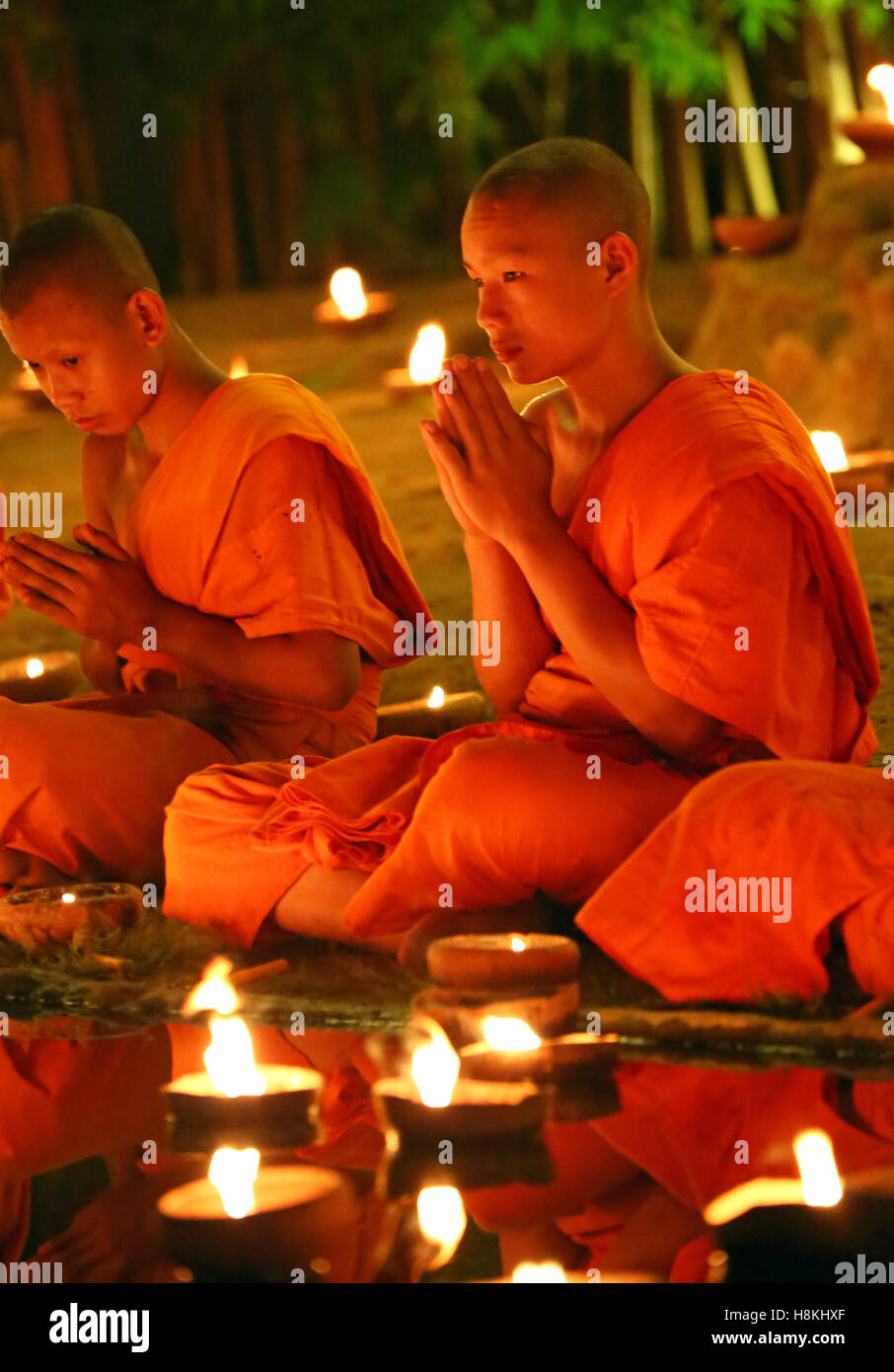 Chiang Mai, Thailand. 14th November 2016. Monks celebrate the Loy Krathong festival at Wat Phan Tao Temple, Chiang Mai, Thailand with candles and sky lanterns in a sombre and moving ceremony which reflects the mourning for King Bhumibol. All the Loy Krathong festivities were reduced in Chiang Mai and across Thailand as a mark for respect, focusing more on the religious aspects of the festival. Credit: Paul Brown/Alamy Live News Stock Photo