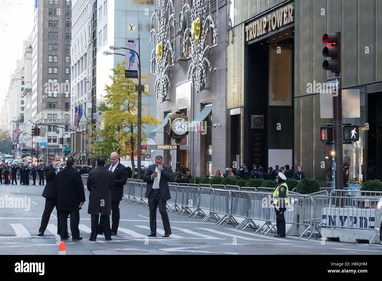 New York, USA. 13th November, 2016. NYC Police Commissioner New York, USA. 13th November, 2016. James P. O'Neill and other high-ranking NYPD officials convene a meeting on 5th Avenue, New York City, in front of the barricaded Trump Tower, as protestors march in the background. Credit:  barbara cameron pix/Alamy Live News Stock Photo
