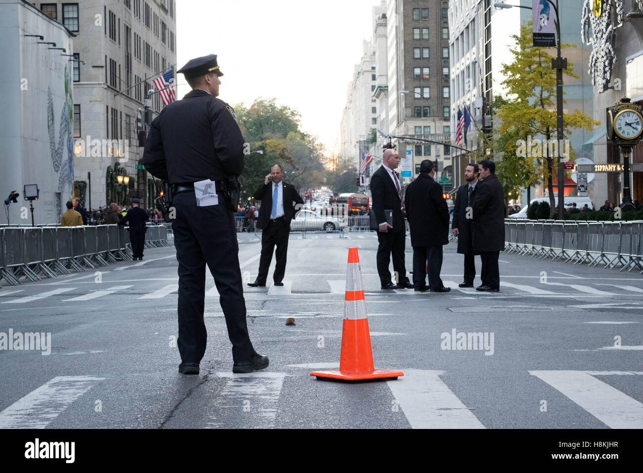 New York, USA. 13th November, 2016. NYC Police Commissioner New York, USA. 13th November, 2016. James P. O'Neill and other high-ranking NYPD officials convene a meeting on 5th Avenue, New York City, in front of the barricaded Trump Tower, as protestors march in the background. Credit:  barbara cameron pix/Alamy Live News Stock Photo