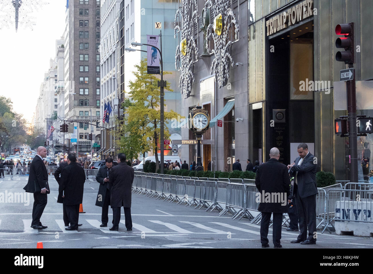 New York, USA. 13th November, 2016. NYC Police Commissioner New York, USA. 13th November, 2016. James P. O'Neill and other high-ranking NYPD officials convene a meeting on 5th Avenue, New York City, in front of the barricaded Trump Tower, as protestors march in the background. Credit:  barbara cameron pix/Alamy Live News Stock Photo
