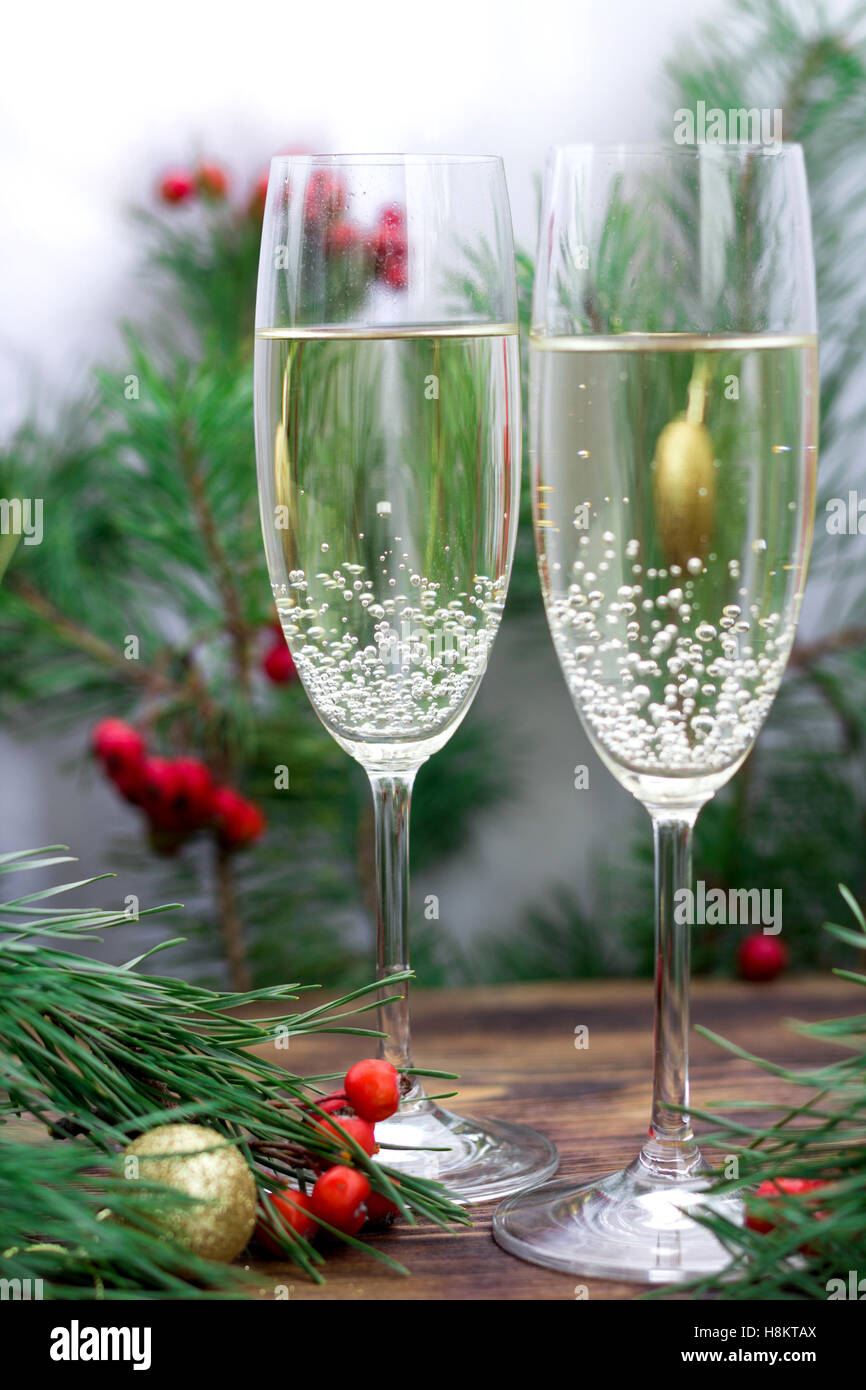 Christmas and New Year seasonal composition with pine tree branches, two glasses of champaign, golden balls ornament and red row Stock Photo