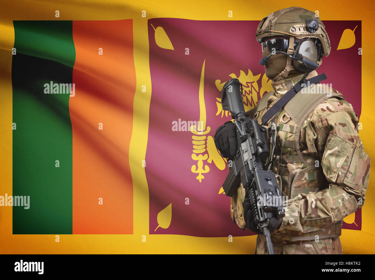 Soldier in helmet holding machine gun with national flag on background