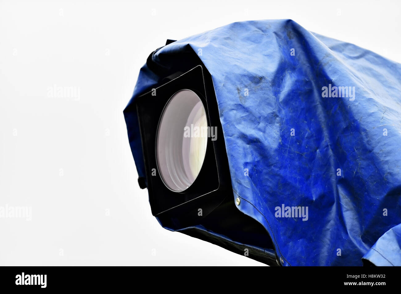 Television news camera on a tripod protected by a blue rain cover Stock Photo