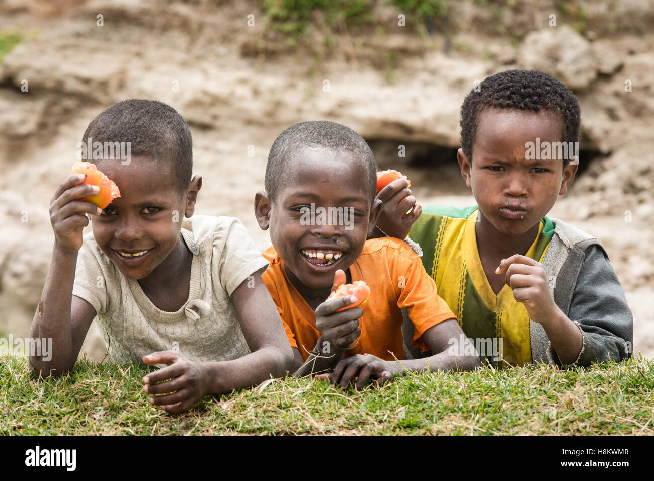 Meki Batu, Ethiopia - Young children laughing and eating tomatoes at the Fruit and Vegetable Growers Cooperative in Meki Batu. Stock Photo