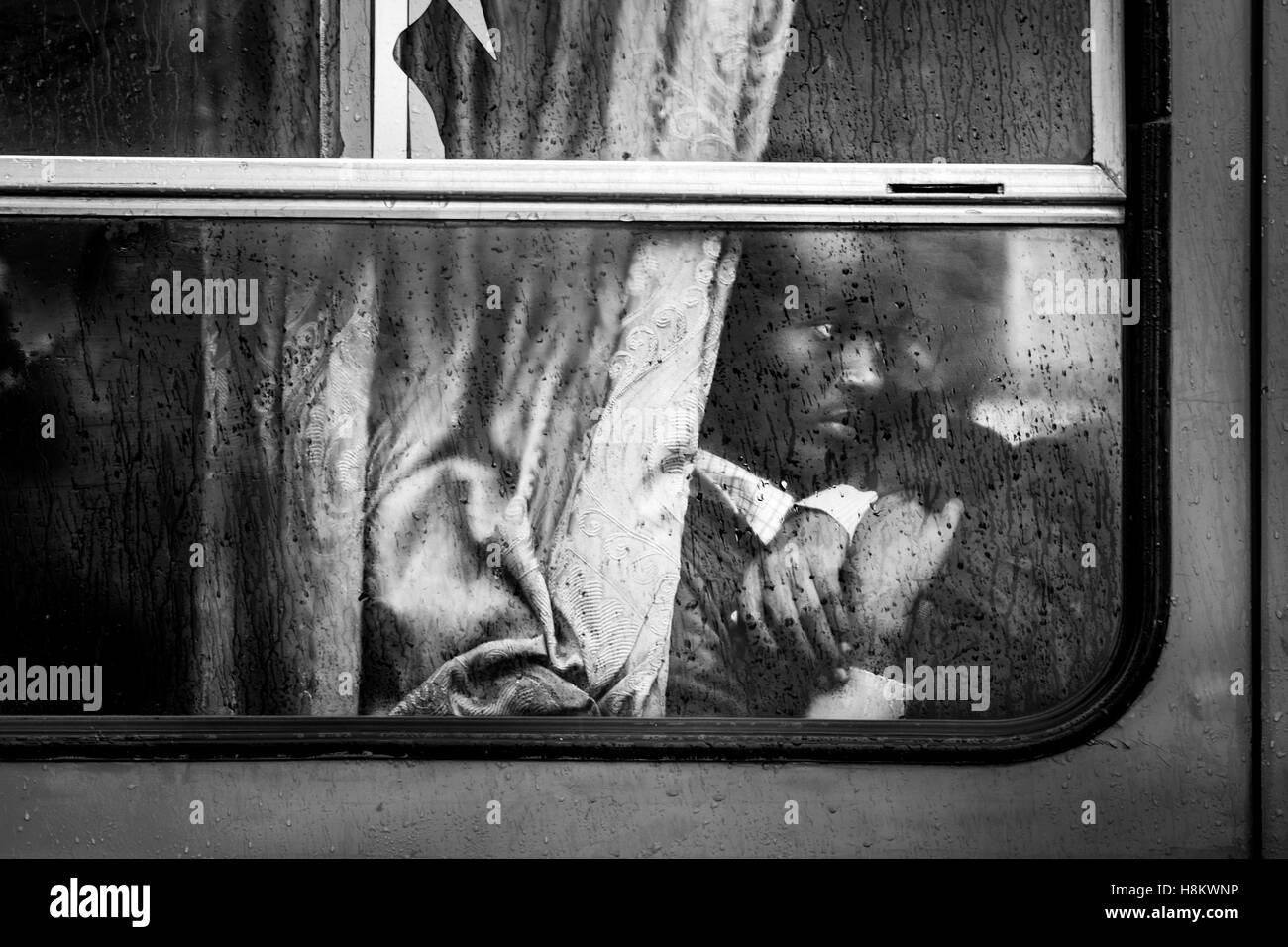 Meki Batu, Ethiopia - Dramatic portrait of an Ethiopian man sitting inside a bus while it rains outside in Meki Batu. Stock Photo