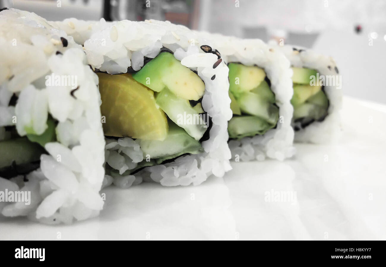 Japanese cuisine. Closeup of fresh veggie maki rolls with avocado. Stock Photo