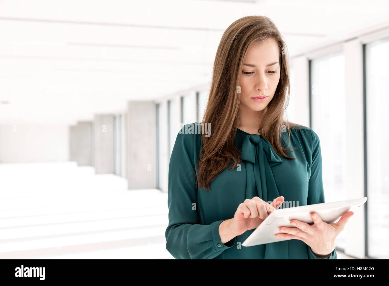 Beautiful young businesswoman using tablet computer in new office Stock ...