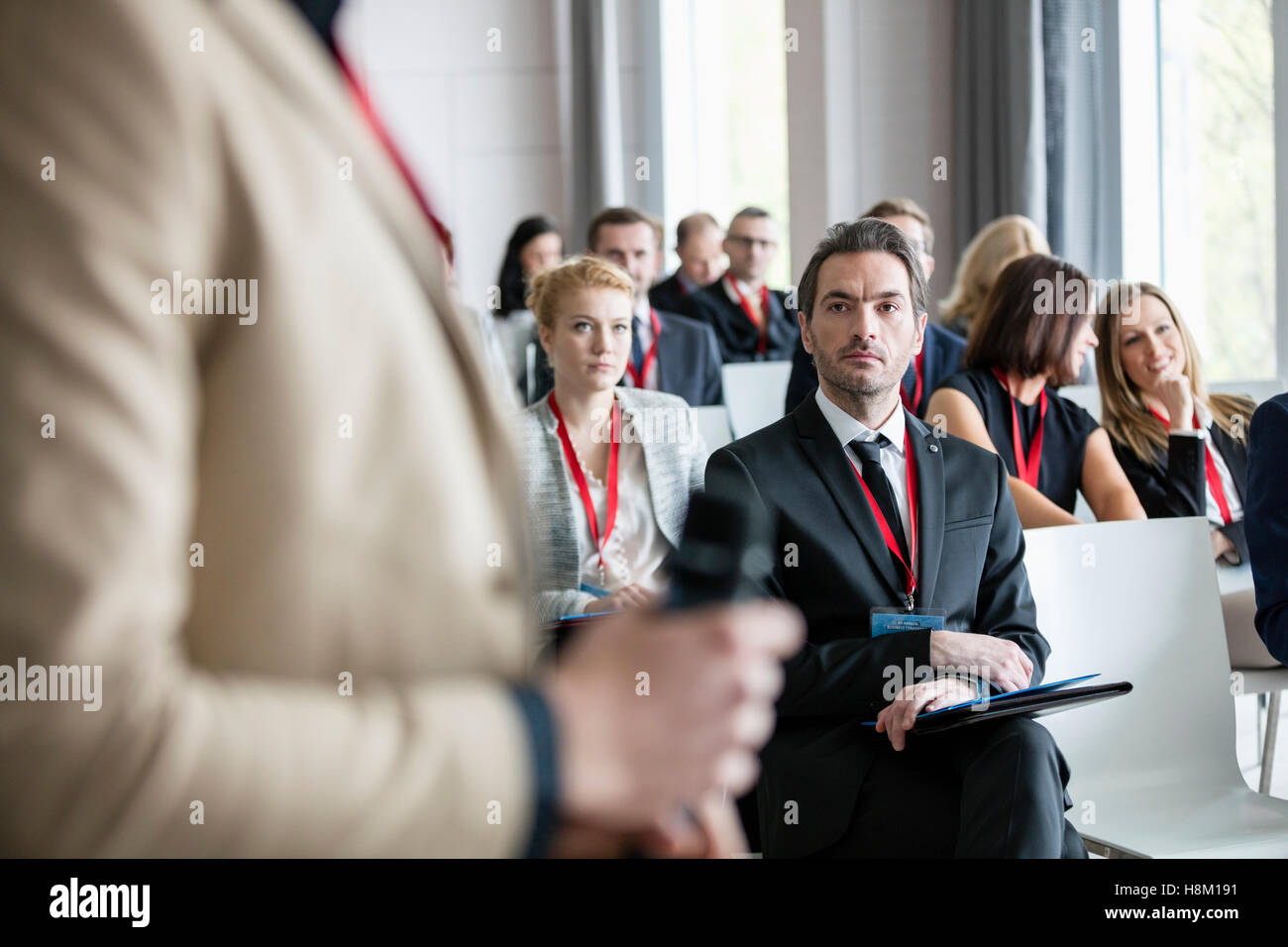 Businessman looking at public speaker during seminar Stock Photo