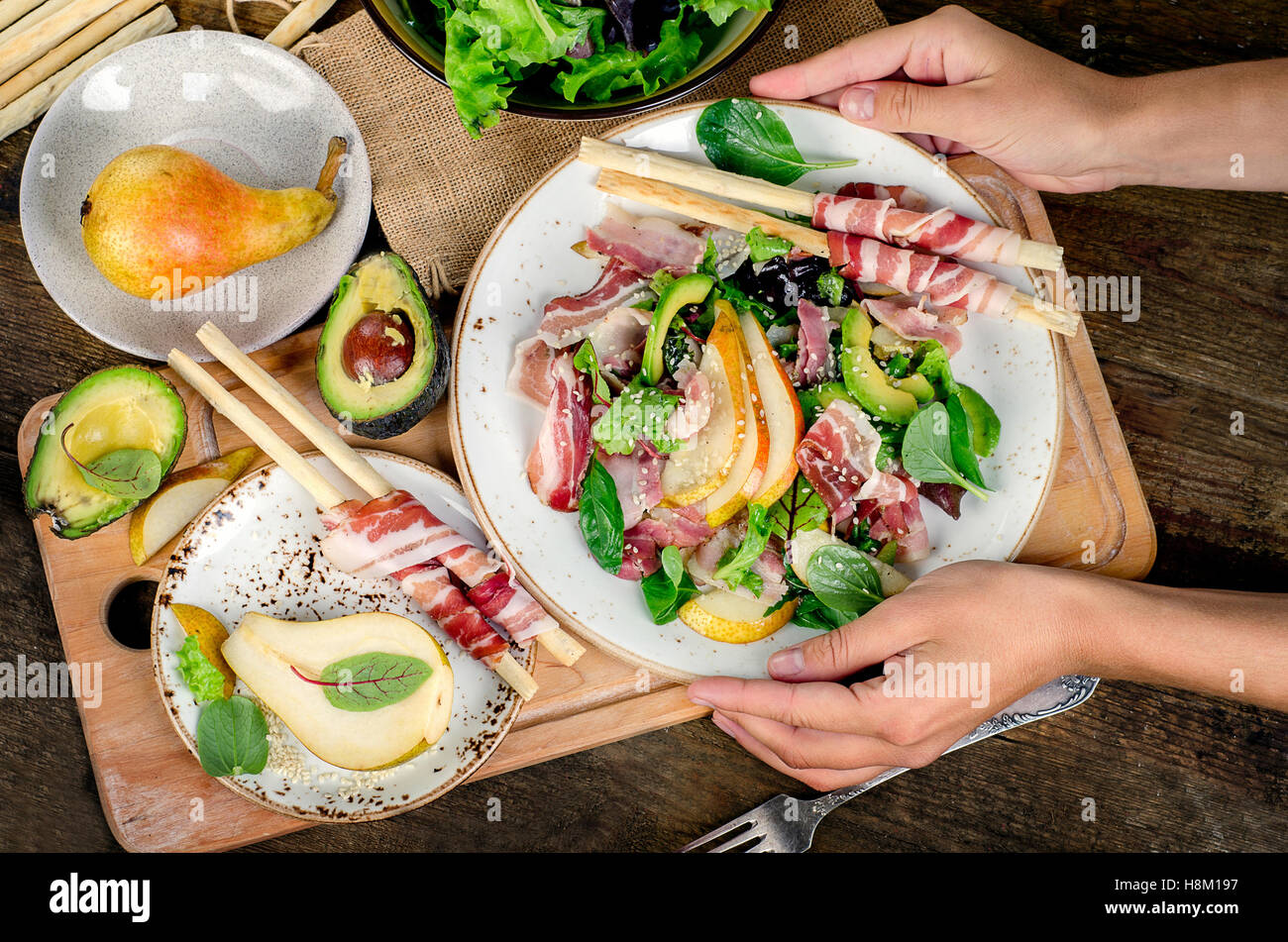 Woman hands holding plate with fresh salad. Top view Stock Photo