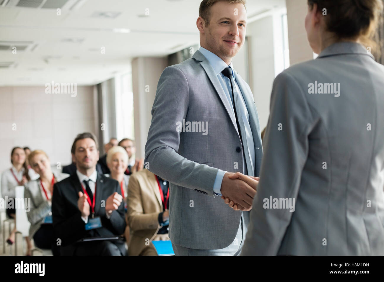 Confident businessman greeting public speaker during seminar Stock Photo