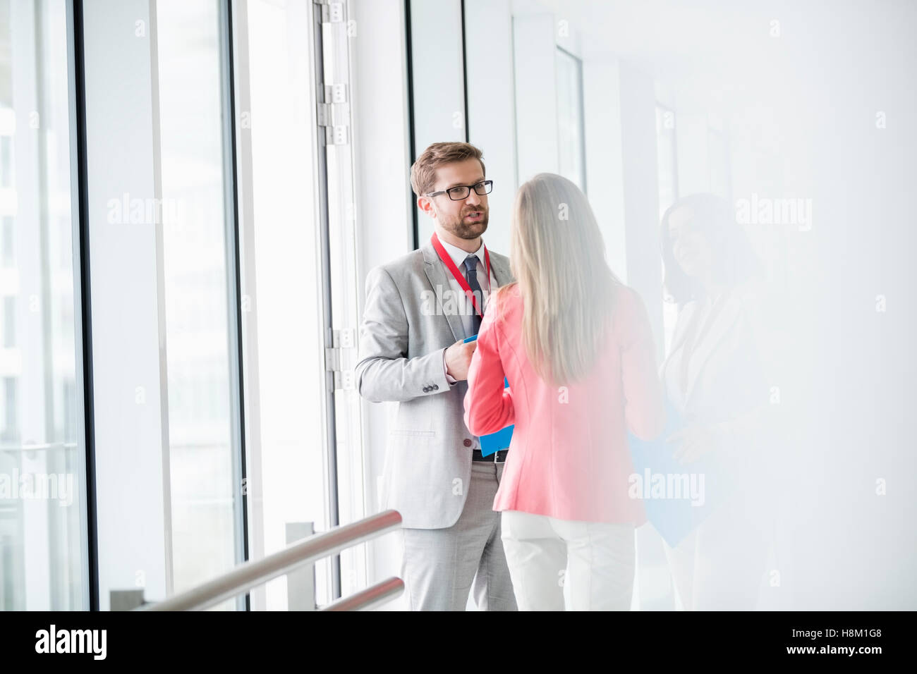 Business people discussing in brightly lit convention center Stock Photo