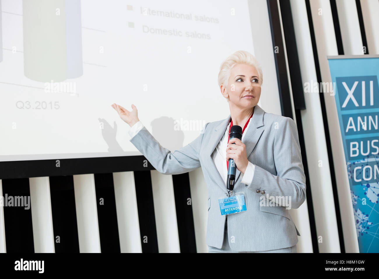 Businesswoman explaining strategy on projection screen at convention center Stock Photo