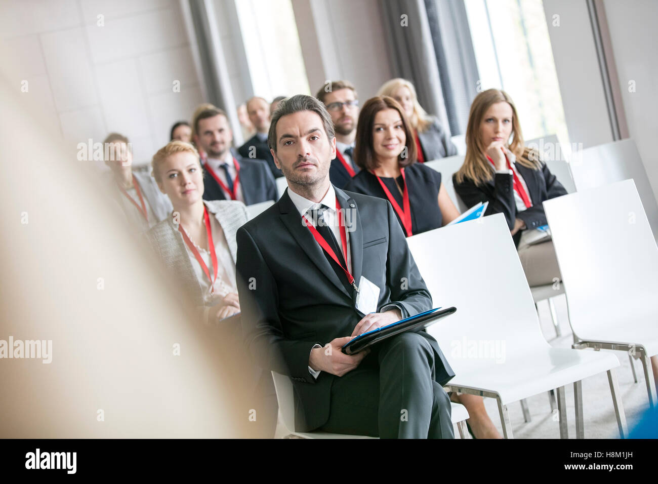 Businessman looking at public speaker during seminar in convention center Stock Photo