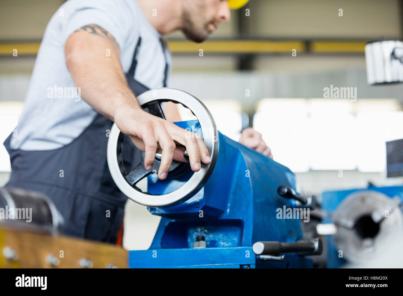 Low angle view of mid adult worker operating machinery in metal industry Stock Photo
